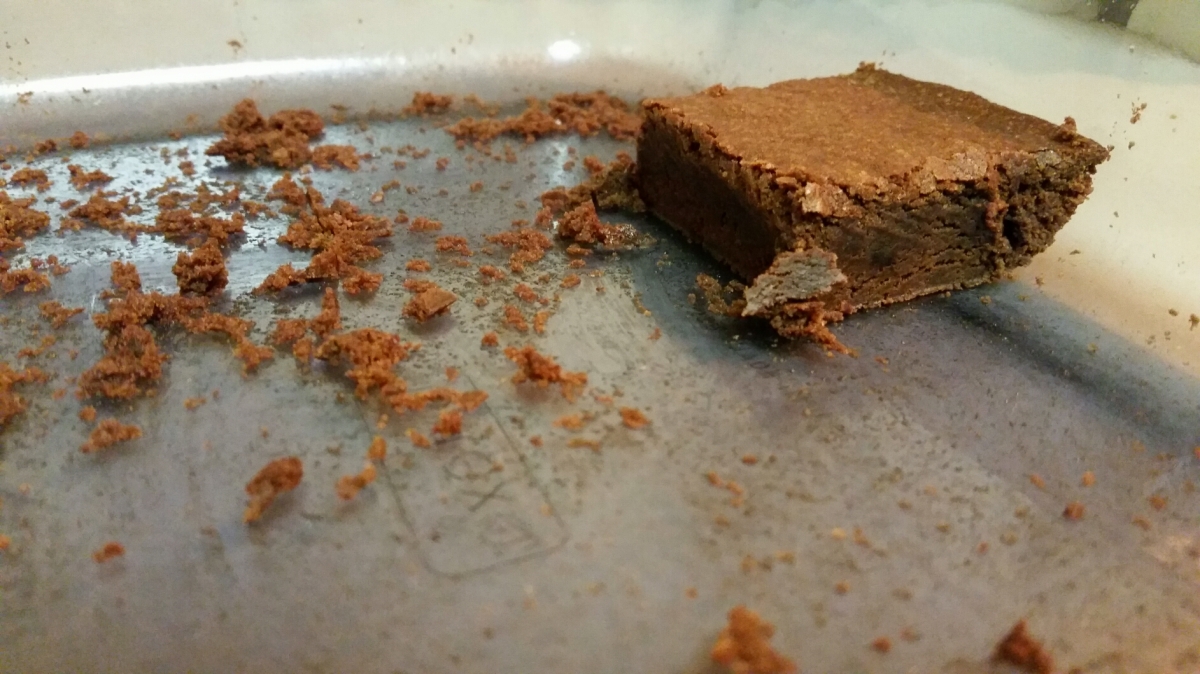 The last brownie in the glass baking pan with crumbs